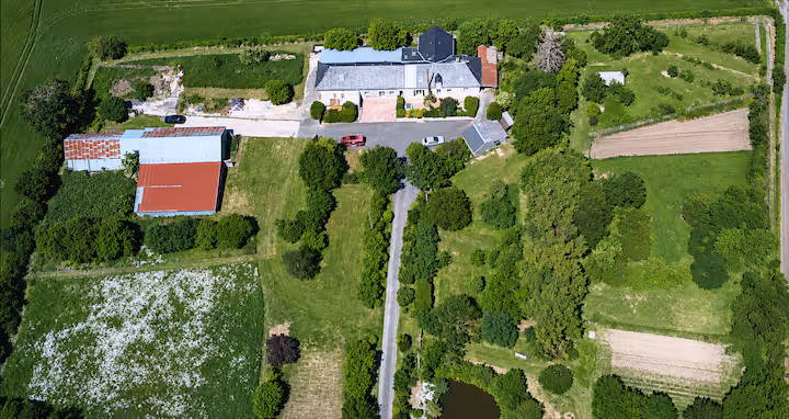 Vue aérienne du lieu-dit Bel-Air, corps de ferme entouré de prairies